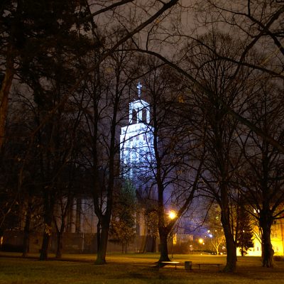 Noční pohled na věž kostela sv. Hedviky zářící modře